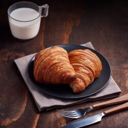 bread on brown wooden tray beside white ceramic mug